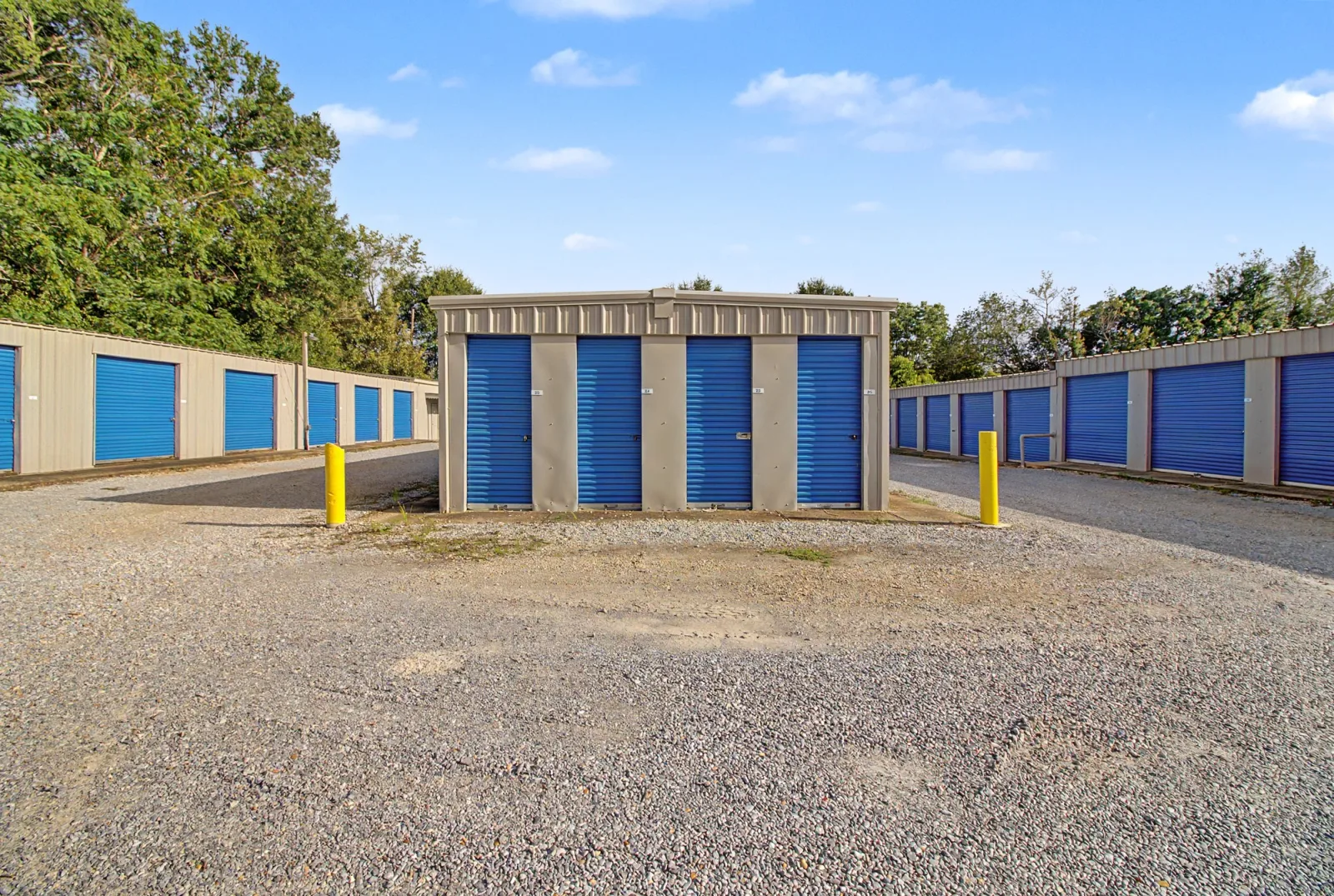 Wide paved drive aisle alongside blue drive-up storage doors at Safelock Storage Dothan